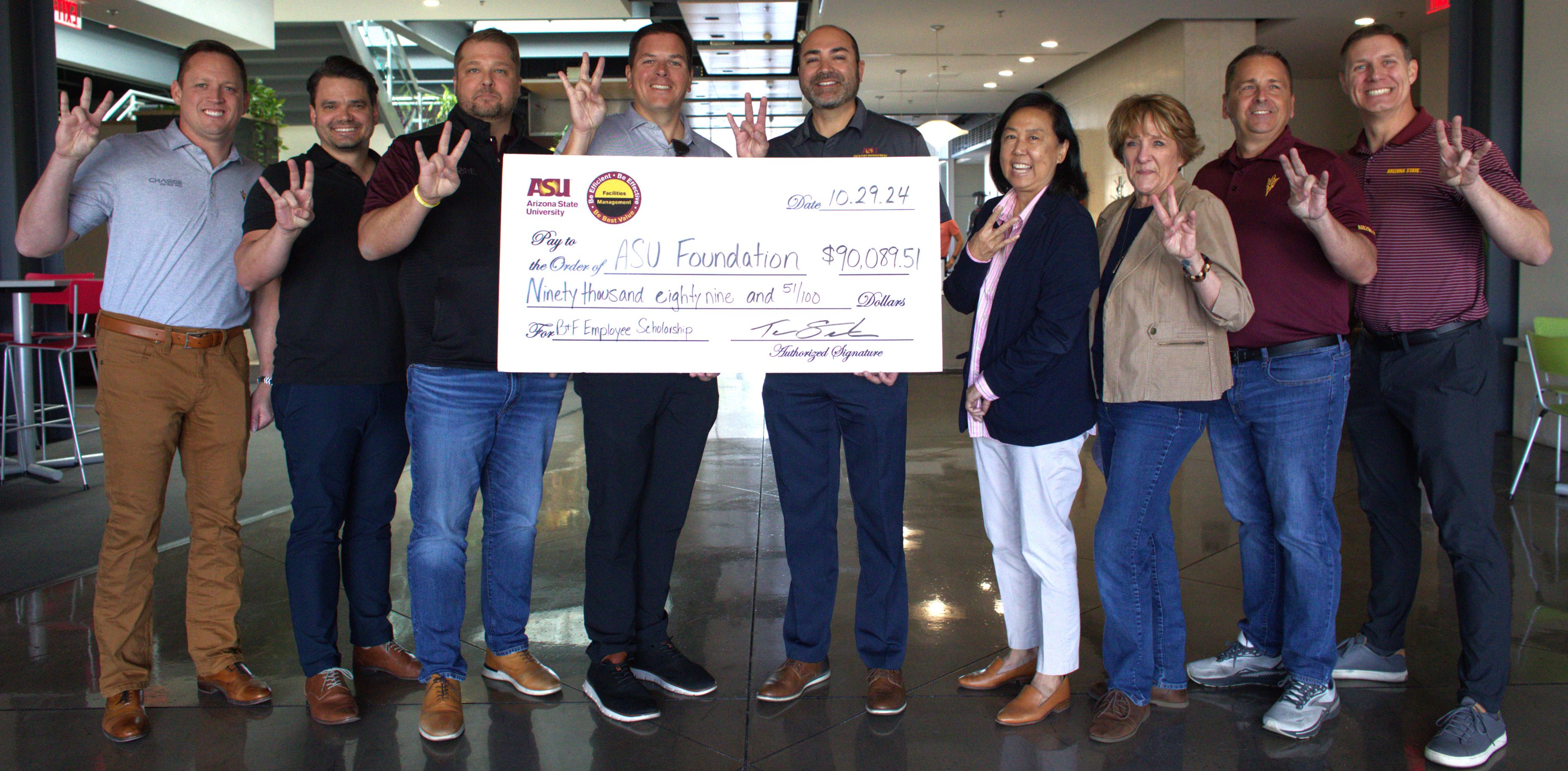 Representatives from ASU and industry partners pose for a photo with an oversized check. 