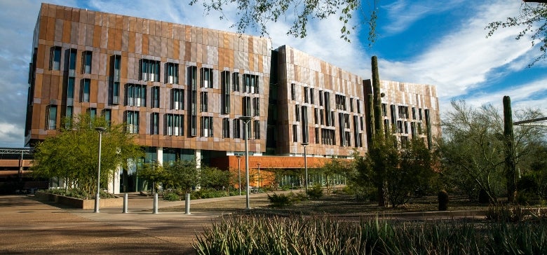 An exterior view of the Biodesign C building featuring desert plants and pedestrian walkways.