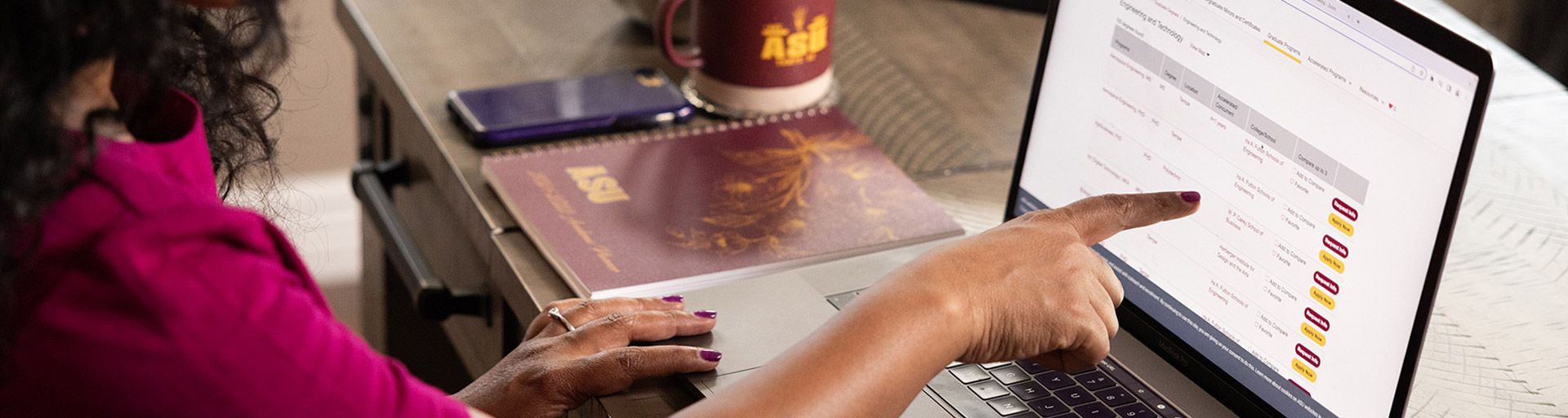 An Alumni using their laptop to search for courses at the ASU Online page. 